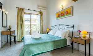 Et soverom med en dobbeltseng, to nattbord med lamper og en balkongdør. Veggen er dekorert med et maleri. (AI-generert tekst)