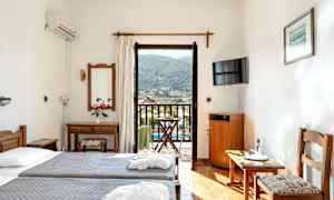 Hotellrom med to enkeltsenger, speil, TV og balkong med utsikt. (AI-generert tekst)