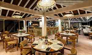 Restaurant med ferdig dekkede bord, stoler og bar i bakgrunnen. (AI-generert tekst)