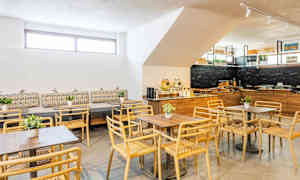 En moderne matsal med trestoler og bord samt dekorasjoner. (AI-generert tekst)