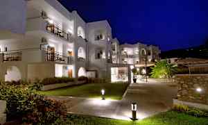 Hvit bygning med balkonger, opplyst om natten. (AI-generert tekst)