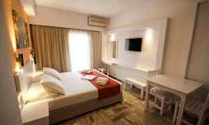 Et hotellrom med en dobbeltseng, TV og sittemøbler. (AI-generert tekst)