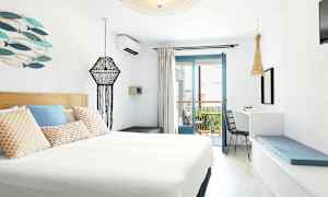 Et moderne innredet hotellrom med lys innredning og en balkong. (AI-generert tekst)