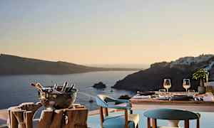 Et dekket bord med to sitteplasser og en utsikt over havet og omkringliggende øyer i solnedgang. (AI-generert tekst)