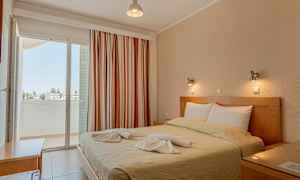 Et soverom med en dobbeltseng, dekorert med håndklær, og en balkong med utsikt. (AI-generert tekst)