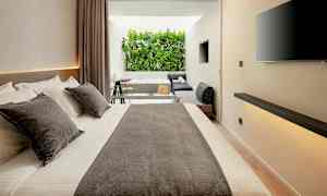 Moderne hotellrom med stor seng, sittegruppe og utsikt mot grøntområder. (AI-generert tekst)