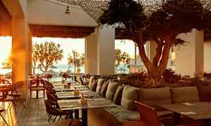 Restaurant med havutsikt og solnedgang. (AI-generert tekst)