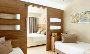 Et hotellrom med delt design, med to senger og en trepanel som skiller rommene. (AI-generert tekst)