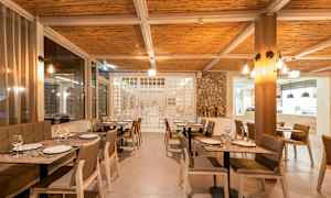 Interiør av en restaurant med dekkede bord og stoler. (AI-generert tekst)