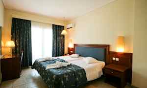 Bilde av et hotellrom med en dobbeltseng, skrivebord og nattbord. (AI-generert tekst)