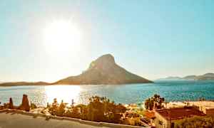 Solrik kyst med fjell og hav i bakgrunnen. (AI-generert tekst)