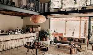 Interiør av en moderne stue med åpen planløsning, inkludert sittemøbler og grønne planter. (AI-generert tekst)