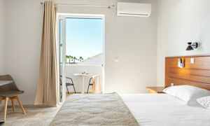 Inne på et hotellrom med seng og balkong. (AI-generert tekst)