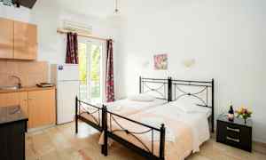 To enkeltsenger med rosa tepper i et rom med kjøkkenutstyr. (AI-generert tekst)