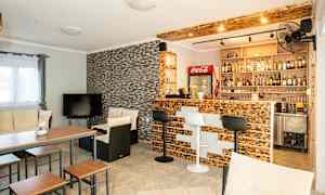 Et stue med bar, sittemøbler og TV. (AI-generert tekst)