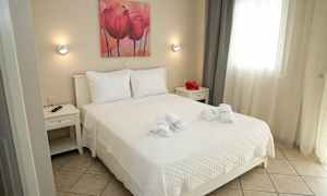 Et lyst og velordnet soverom med en dobbeltseng, hvitt sengetøy og nøytralt innredningsdesign. (AI-generert tekst)