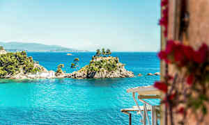 En liten øy med trær og et hus omgitt av blått vann. (AI-generert tekst)