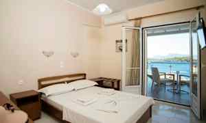 Dobbeltrom med utsikt over havet gjennom en åpen balkongdør. (AI-generert tekst)