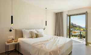 Moderne hotellrom med dobbeltseng og balkong som tilbyr utsikt over et pittoresk landskap. (AI-generert tekst)