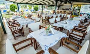 Utendørs restaurantområde med bord og stoler samt dekorasjoner. (AI-generert tekst)