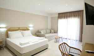 Et hotellrom med en seng, sofa, skrivebord og stoler. (AI-generert tekst)