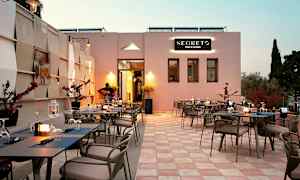 Uteservering ved restaurant med dekkede bord og en musiker som spiller gitar. (AI-generert tekst)