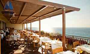 Restaurantterrasse med dekkede bord og havutsikt. (AI-generert tekst)