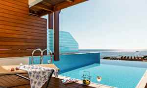 Et infinity-basseng med utsikt over havet, en solseng og en drink. (AI-generert tekst)