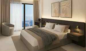 Et hotellrom med en dobbeltseng, sittemøbler og en balkong med havutsikt. (AI-generert tekst)