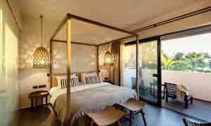 Et soverom med seng og koselig belysning, samt en terrasse utenfor. (AI-generert tekst)