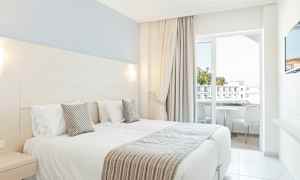 Hotellrom med to enkeltsenger og balkong. (AI-generert tekst)