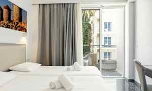 Hotellrom med to enkeltsenger, balkong med utsikt. (AI-generert tekst)