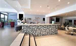 En hotellresepsjon med detaljert benkeplate og sitteplasser. (AI-generert tekst)