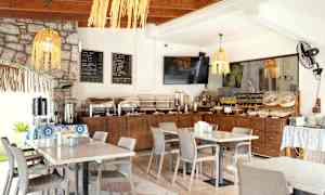 Frokostbuffet i en lys restaurant med dekkede bord. (AI-generert tekst)