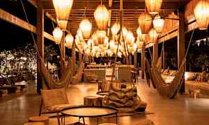 Et nattlig loungeområde med hengende lamper og sittemøbler. (AI-generert tekst)