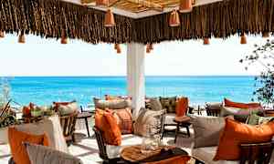 Terrasse med komfortable sitteplasser og utsikt over havet. (AI-generert tekst)