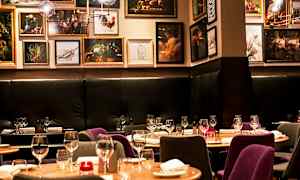 Interiør av en restaurant med dekkede bord og kunstverk på veggene. (AI-generert tekst)