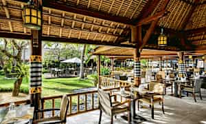 En restaurant med utendørs sitteplasser, omgitt av grønt. (AI-generert tekst)