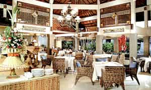 Restaurant med rottingmøbler og hvite duker. (AI-generert tekst)