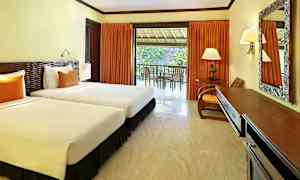 Et hotellrom med to enkeltsenger, et skrivebord og en balkong med utsikt. (AI-generert tekst)