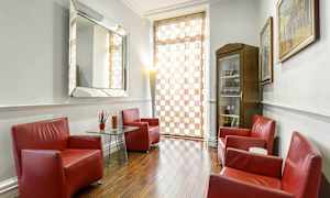 Et rom med røde lenestoler rundt et bord, et speil og tregulv. (AI-generert tekst)