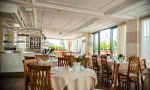 En restaurant med dekkede bord og utsikt mot en bygning med kuppel. (AI-generert tekst)