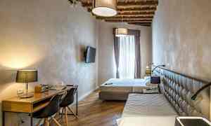 Et hotellrom med to senger, skrivebord og flatskjerm-TV. (AI-generert tekst)