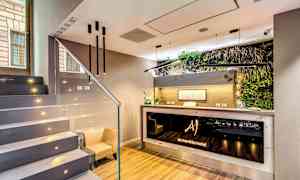 Bildet viser en moderne hotellresepsjon med minimalistisk interiør og plantepynt ved disken. (AI-generert tekst)