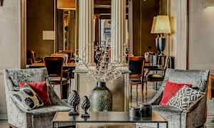 To lenestoler med puter foran et bord med dekorasjonsgjenstander, i et elegant innredet miljø. (AI-generert tekst)