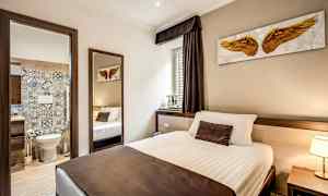 Et hotellromsinteriør med en seng og en åpen dør til et bad. (AI-generert tekst)