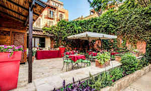 Uteareal med bord og stoler samt vegetasjon. (AI-generert tekst)