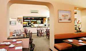 Et restaurantområde med bord og stoler, samt en buffé serveringsområde. (AI-generert tekst)