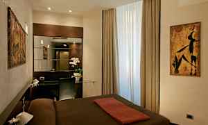 Et hotellrom med moderne innredning, et vindu med lysinnfall, et speil og en skrivebordsflate med stol. (AI-generert tekst)