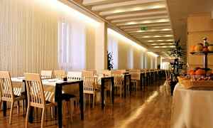 Bilde av en restaurant med bord og stoler, tregulv og frukt på et bord. (AI-generert tekst)